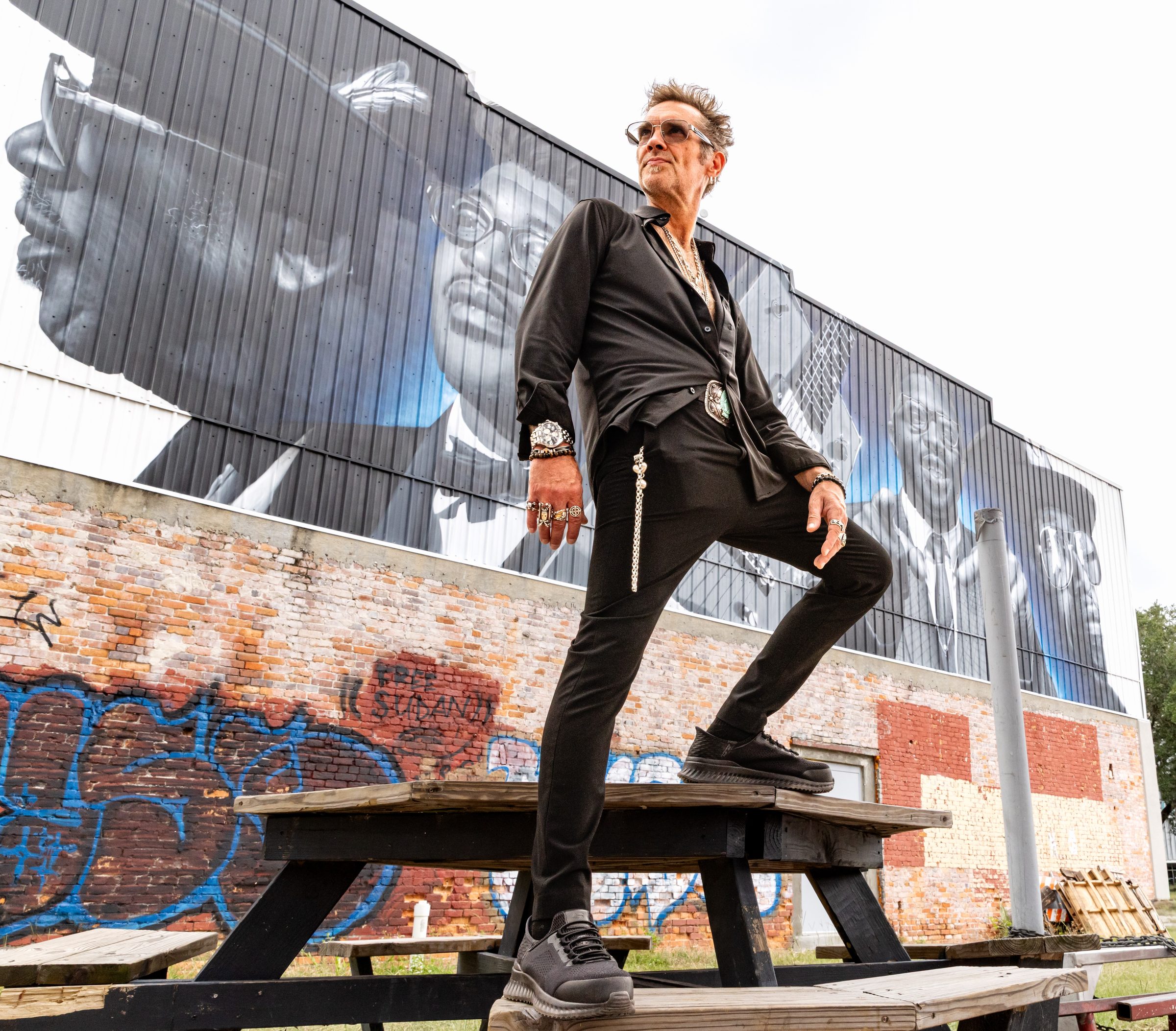 Bo Bice standing on a picnic table in front of a mural